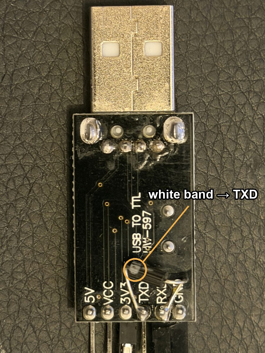 Solder side of the adapter with a diode soldered between the TXD and RXD pads; the white band at the TXD end is circled